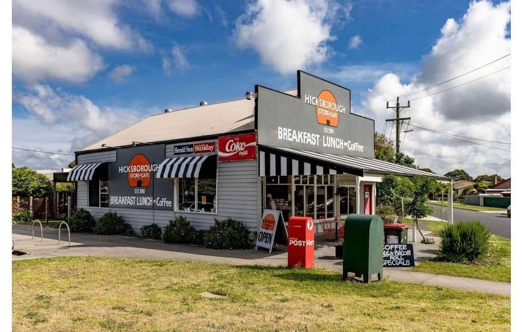 Hicksborough Store & Cafe exterior — white weatherboard corner building with striped awnings and bold signage