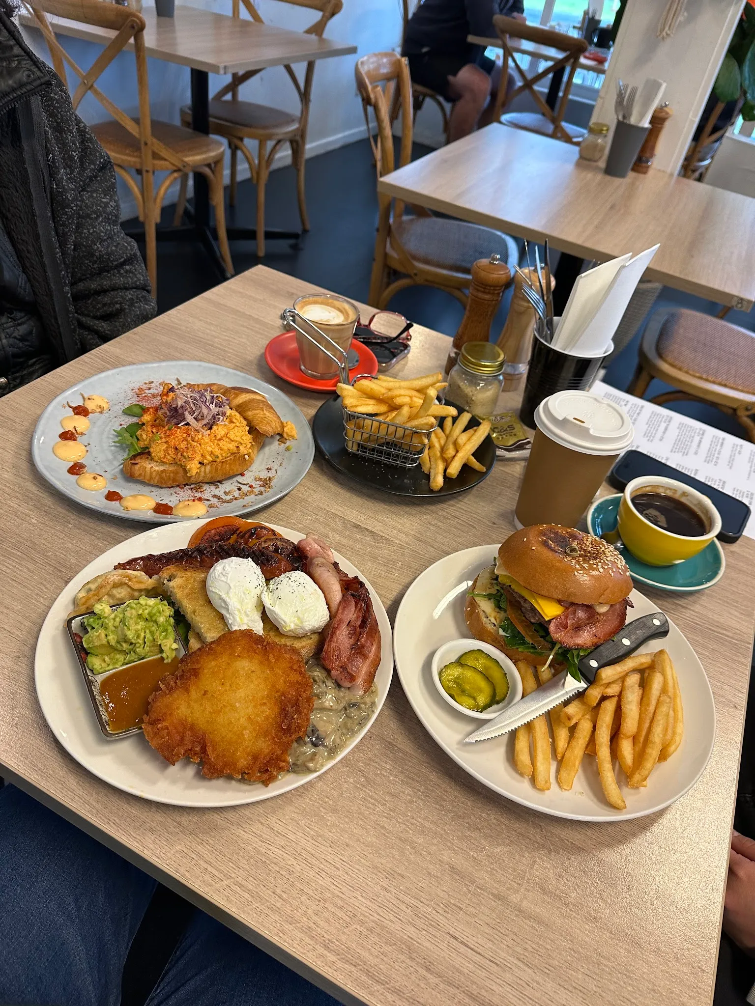 Four Hicksborough dishes on a table including a full breakfast, burger, salmon cake and coffee