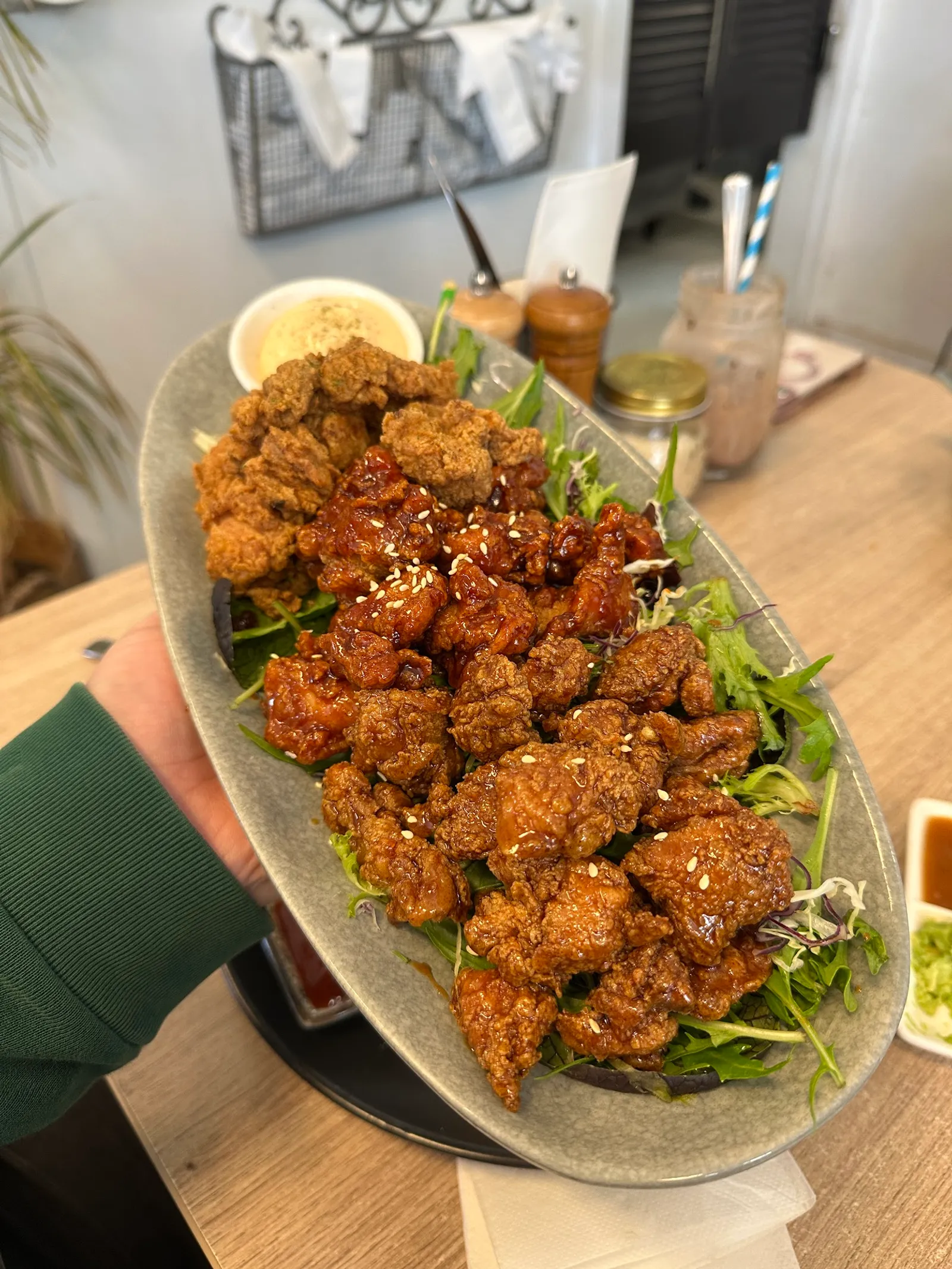 Platter of crispy Korean fried chicken pieces held up in the Hicksborough cafe